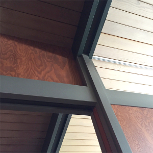 New marine ply walls and painted columns meeting existing roof beams and wood plank ceiling