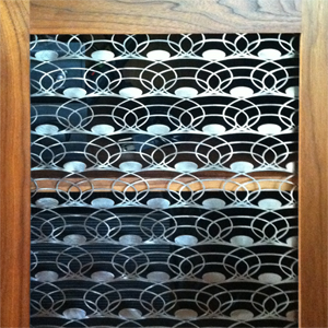 Custom laser-cut metal screen in a Walnut cabinet